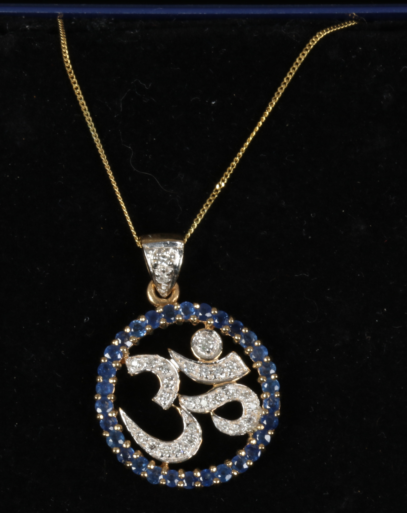 A 9ct gold pendant chain, set with sapphire and diamond to form the Sanskrit OM symbol.