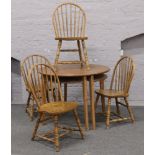 Two Ikea pine demi lune Laurila tables, along with a set of four oak spindle back chairs.