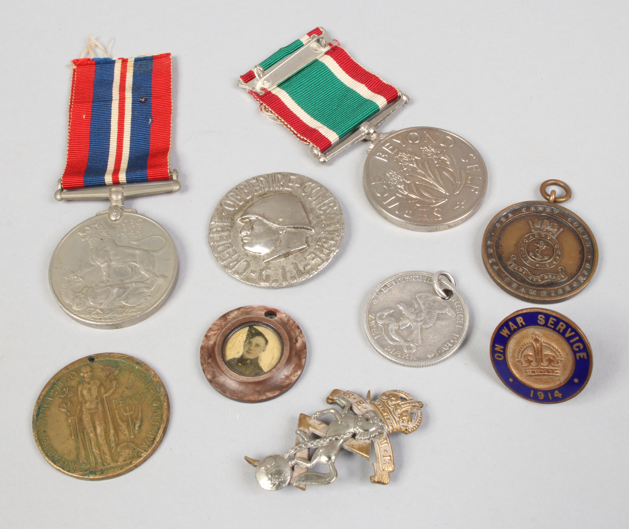 A quantity of commemorative medals, along with pin badges and a Unity and Honour example.