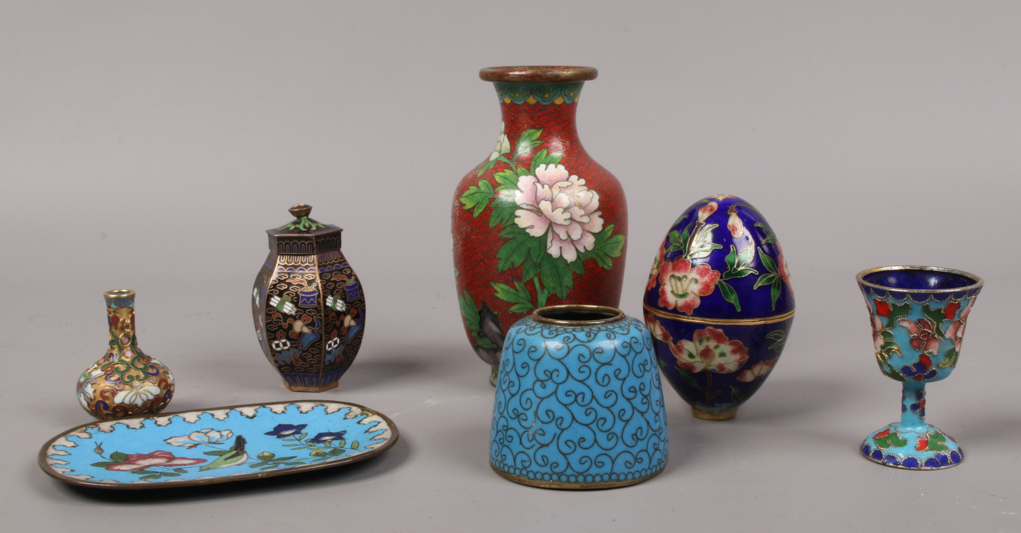 A quantity of cloisonne ware including a red ground baluster shaped vase, trinket dish etc.
