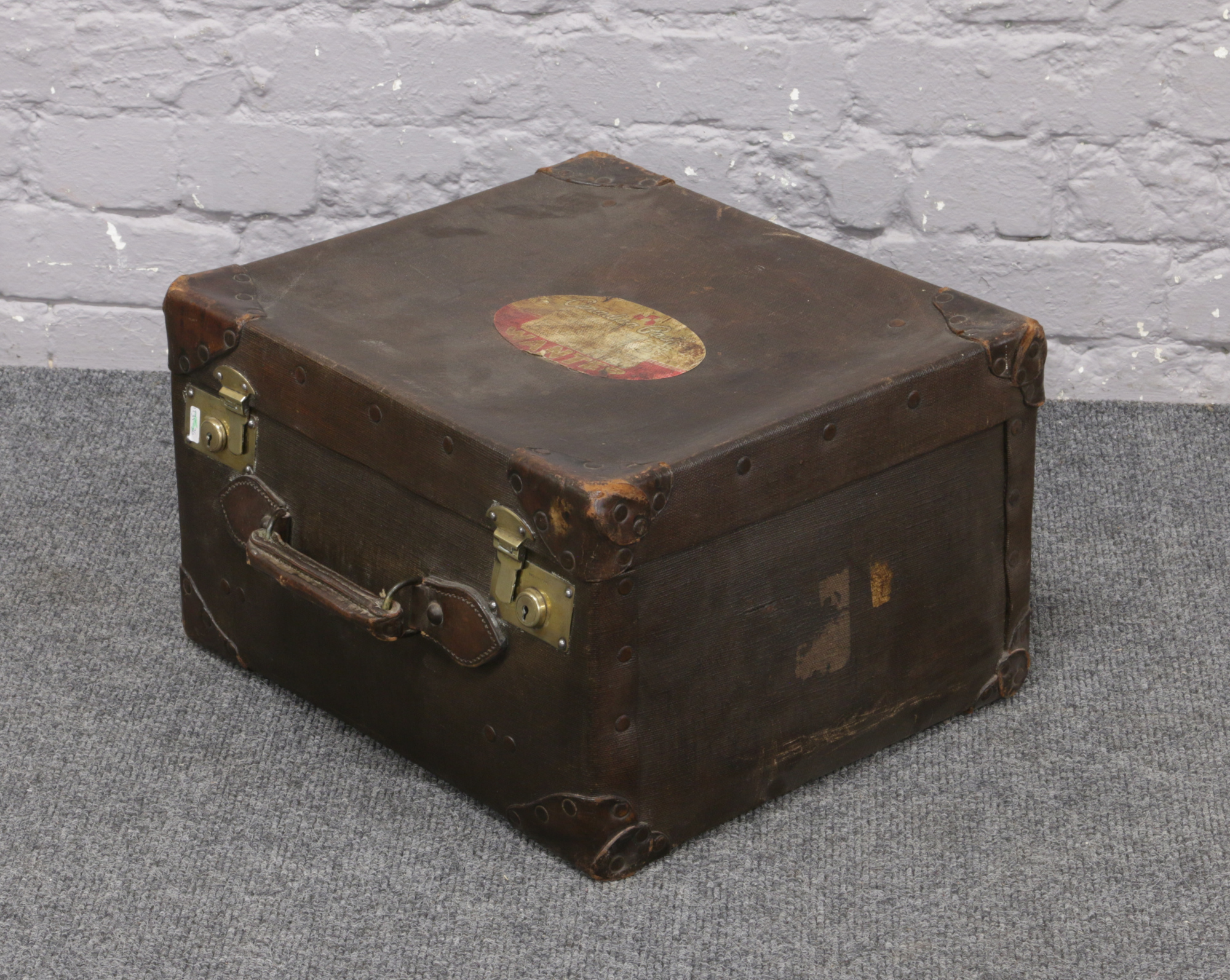 A vintage canvas case with leather mounted corners and brass locks.