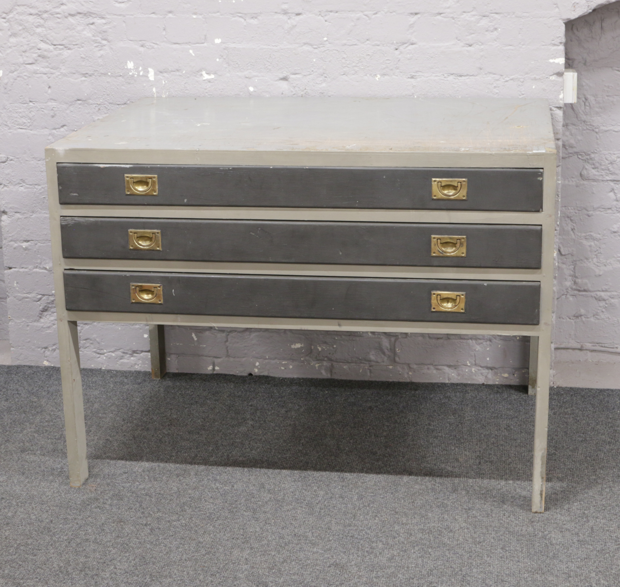 A grey painted three drawer plan chest of drawers.