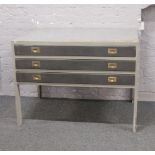 A grey painted three drawer plan chest of drawers.