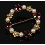 A 9ct gold garnet and pearl wreath brooch.