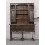 A carved and panelled oak lead glazed dresser, raised on barleytwist supports, Width 130cm x Depth