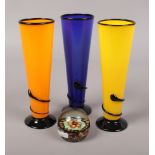 Three New Zealand colour art glass vases, along with a glass spilt cane paperweight.