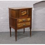 A mahogany and walnut cupboard, raised over turned castered legs with brass metal mounts.