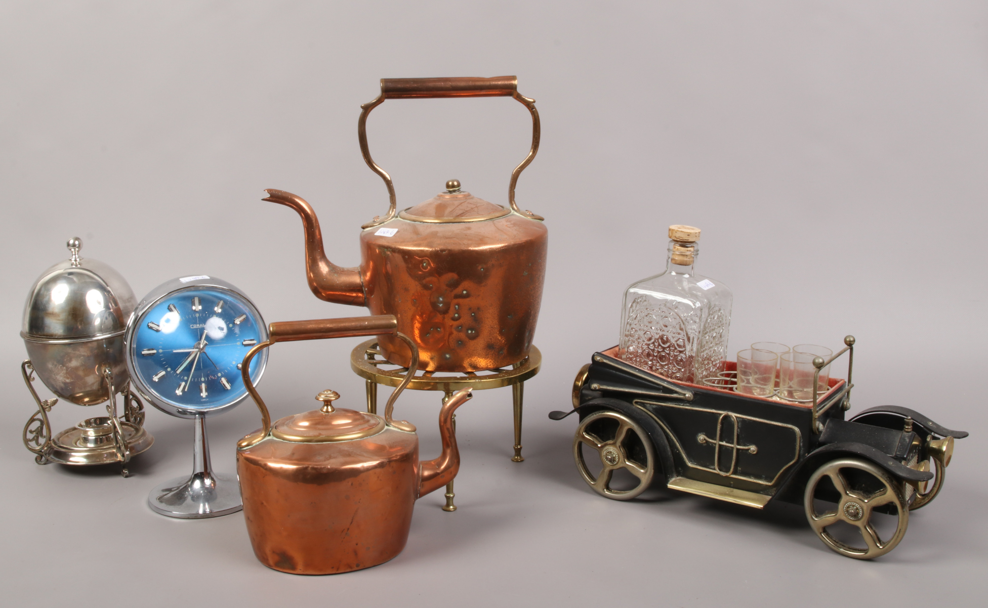 Two copper kettles, brass trivet, Elkington & Co. spirit egg coddler, along with coral 1970s clock