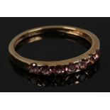 A 9ct gold dress ring set with seven pink tourmaline gemstones, size O.