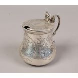 A mid Victorian silver mustard pot chased with flowers and scrollwork having a gilt interior,