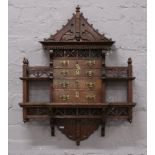 An Edwardian oak hanging break-front wall cabinet with brass mounts. Comprising a bank of four