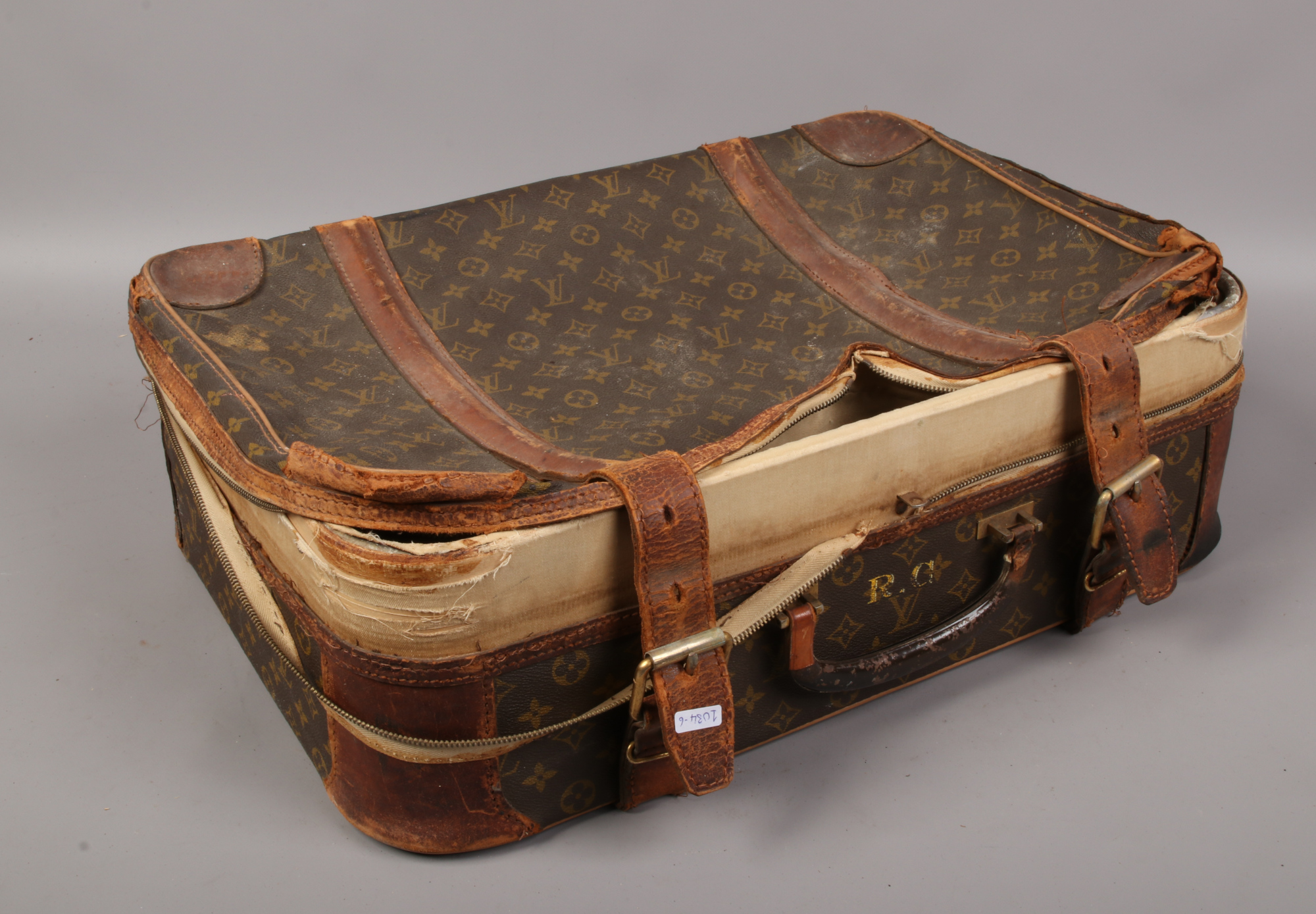 A Louis Vuitton leather bound suitcase stencilled R.G.