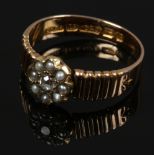 A 15ct gold seed pearl and diamond floriform set ring with reeded shoulders, size M.