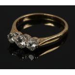 An 18ct gold three stone diamond ring set with brilliant cut stones, approximately 0.6ct total.