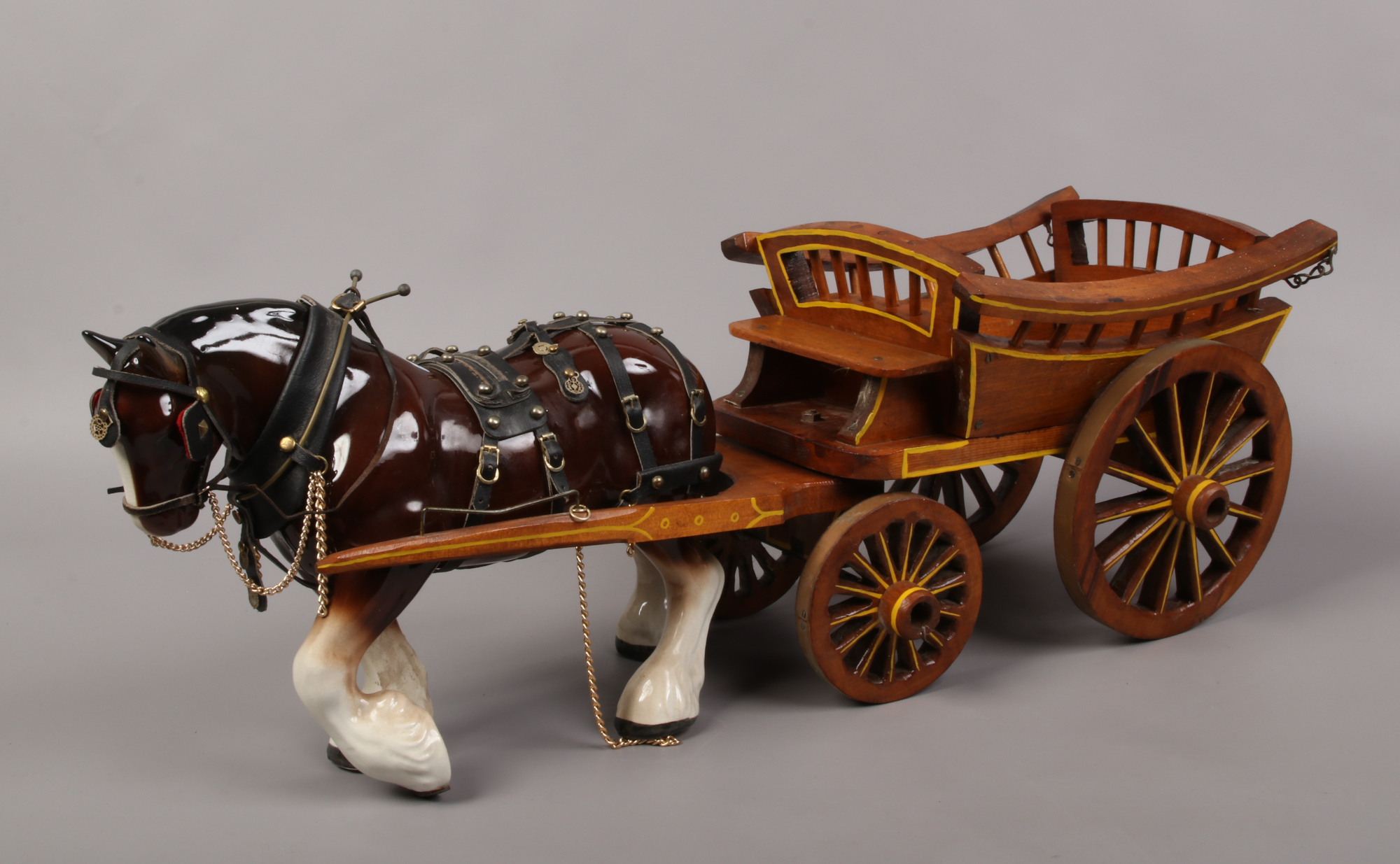 A large ceramic shirehorse in full harness and cart.