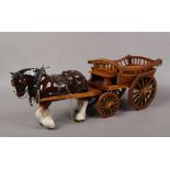 A large ceramic shirehorse in full harness and cart.