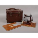 A vintage cased childs hand crank sewing machine.