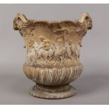 A Victorian earthenware urn moulded with twin ram masks, decorated with putti and fauns, impressed