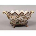 A decorative continental 18th century style rose bowl with metal mount, raised on paw feet.