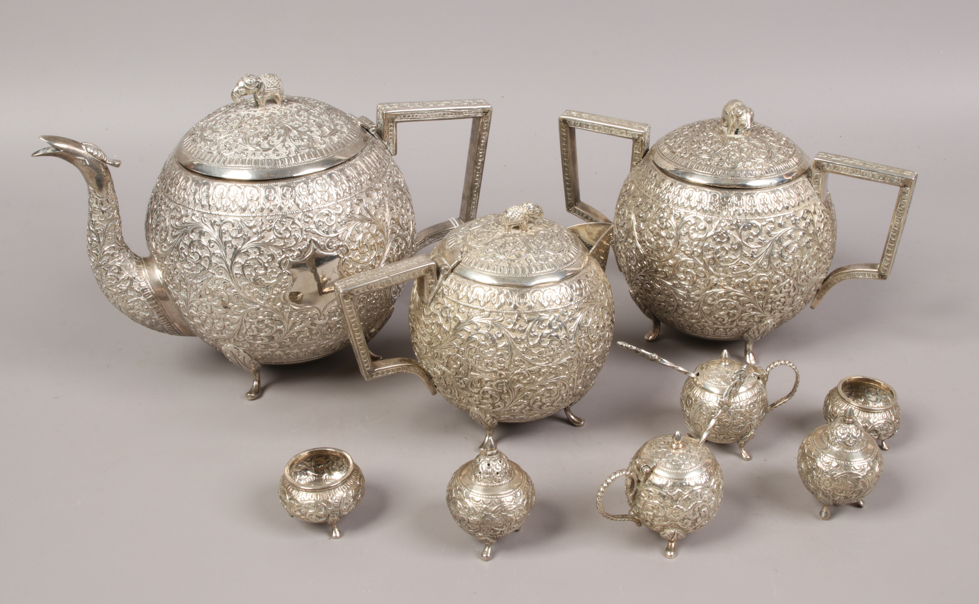 An Indian silver tea service of spherical form, comprising teapot, sugar bowl, hot water jug, cruets