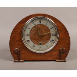A carved oak Anvil dome top mantle clock striking on four gongs, movement stamped perivale.