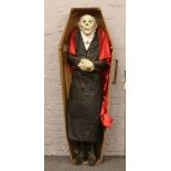 A fibre glass life size model of Count Dracula in a coffin with illuminating battery powered eyes.