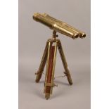 A pair of decorative brass binoculars raised on brass and wood tripod.