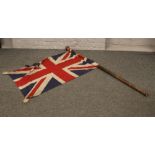 A World War I era weighted canvas Union flag on a bamboo pole with turned finial, flag 68cm x
