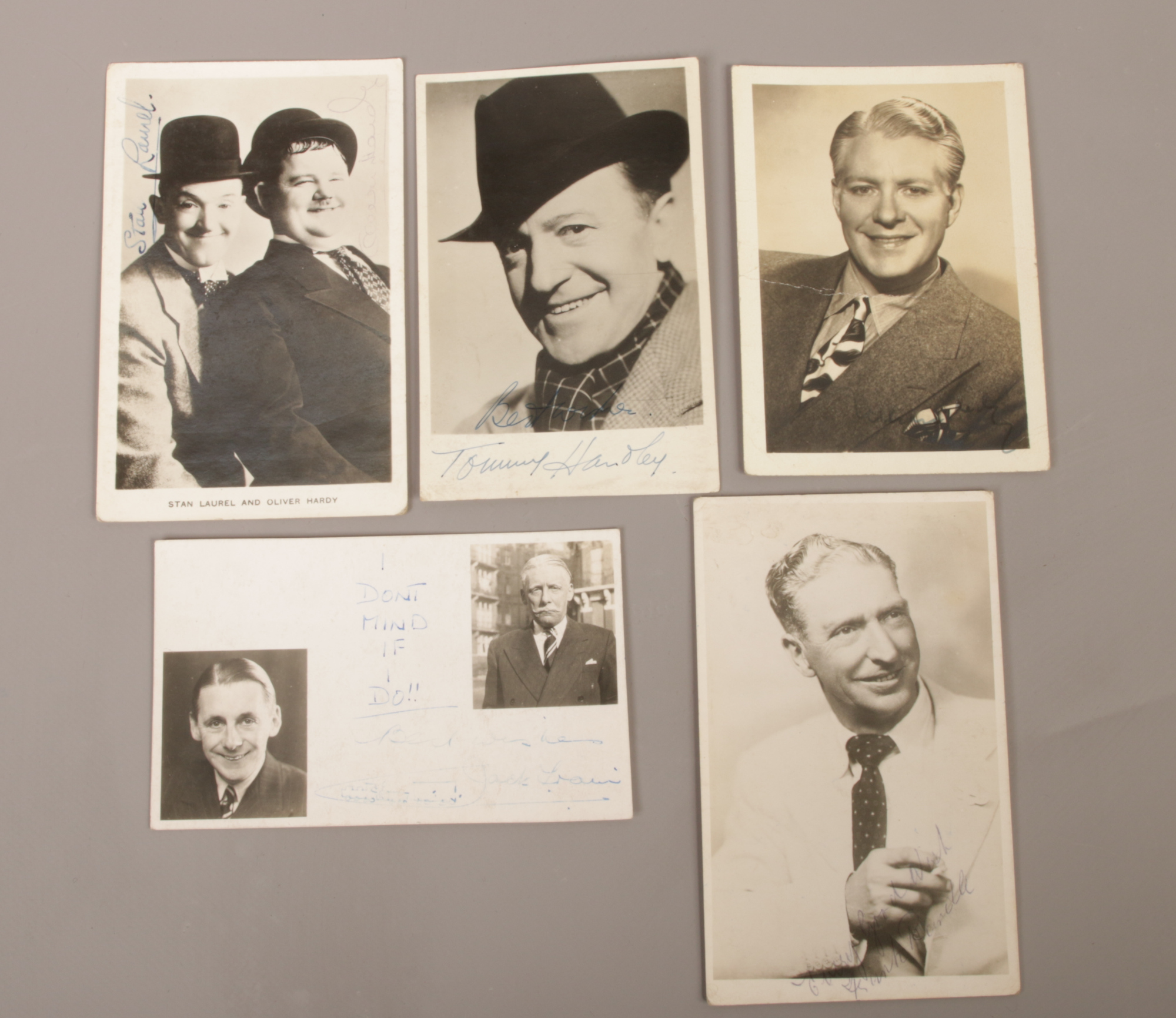 A collection of autographed photographs to include Laurel and Hardy, Tommy Handley, Jack train etc.