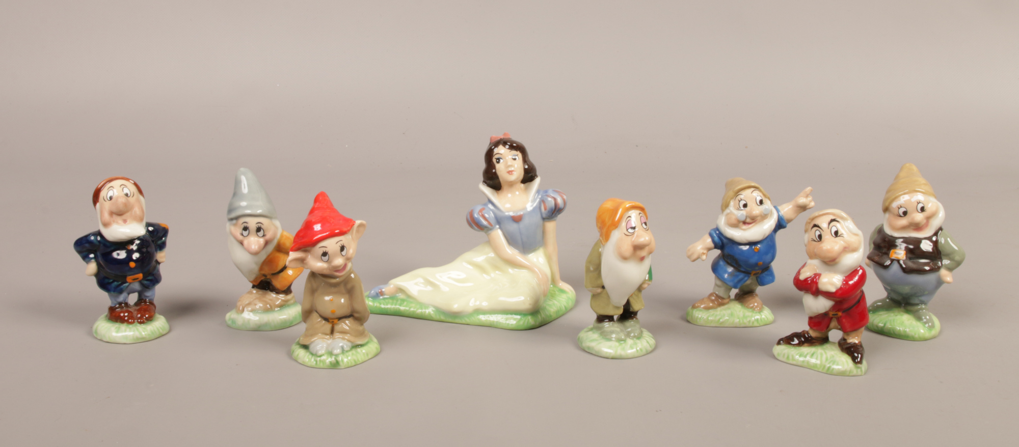 An assembled set of Wade ceramic Disney's Snow White and the Seven Dwarfs figures.