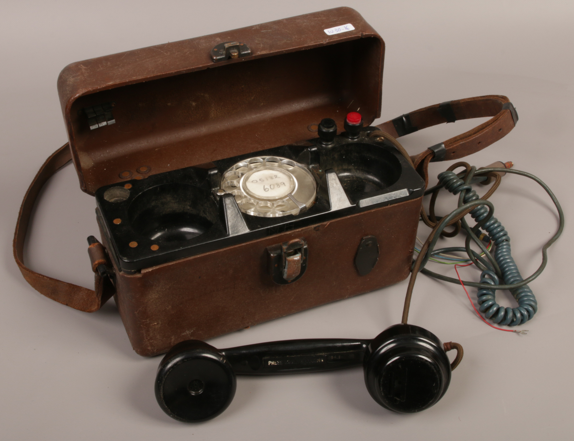 A vintage cased telephone linesman engineers phone line tester with Rotary dial.