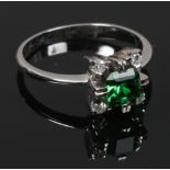 An 18ct white gold and four stone diamond ring with green coloured paste centre stone acid test as