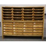 An early 20th century scumble glazed drapers shop cabinet comprising two banks of 20 reversible