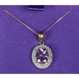 A 9ct gold amethyst and diamond pendant on chain. Set with a large ovoid amethyst under a two row