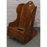 A 19th century childs ash and oak rocking chair commode.