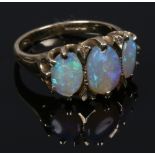 A 9ct gold three stone opal ring in claw settings. Size I 1/2.