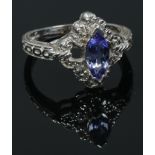 A 14ct white gold ring set with a marquis cut tanzanite stone and diamonds and with milgrain