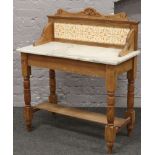 A Victorian carved pine washstand with tiled splashback raised over turned square cut legs.