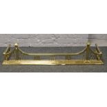 A victorian brass fire fender raised on stepped plinth.