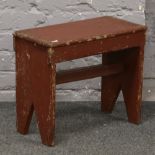 A rustic painted wooden stool.