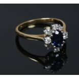 An 18ct gold (tested) sapphire and diamond cluster ring. Sapphire approximately 7mm x 5mm. Size N