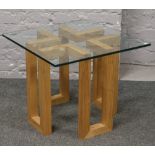 A modern decorative light oak coffee table with glass top.