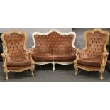 A French carved walnut two seat sofa upholstered in pink along with two matching armchairs for re-