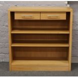A modern light oak shelving unit with two drawers.
