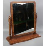 A large figured mahogany toilet mirror with turned supports.