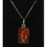 A sterling and amber pendant on trace chain.