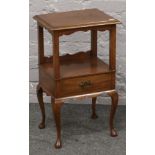 A mahogany two tier side table with single drawer and raised on cabriole legs.