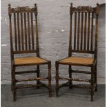 A pair of Jacobean style stick back side chairs with carved scroll formed cresting rails and