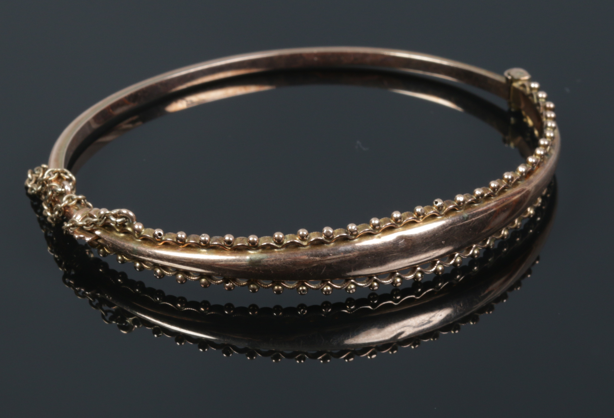 A 9ct gold bangle with beaded edge, 6.1 grams.