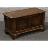 A panelled oak blanket box, raised on bracket feet.